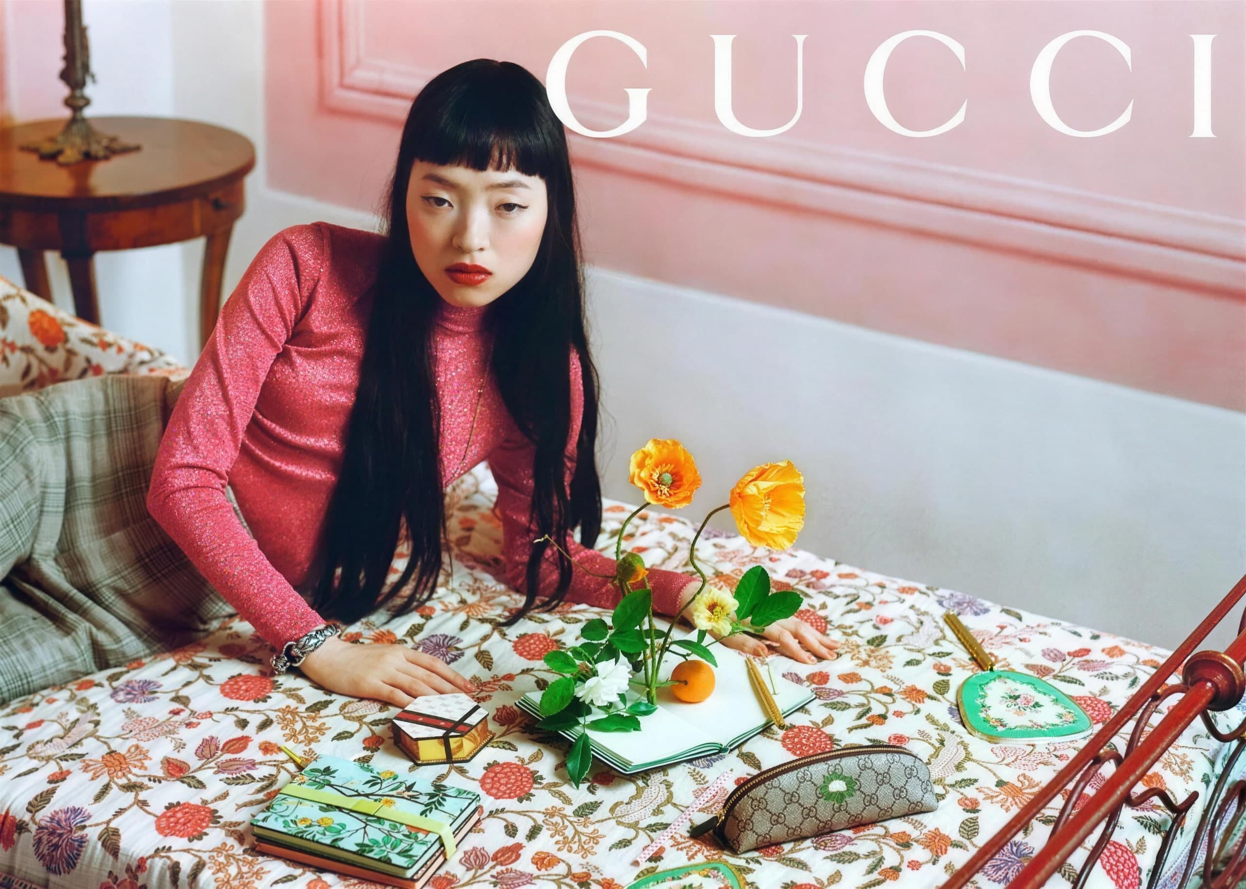Gucci campaign: a model at a floral-covered table in a pink room
