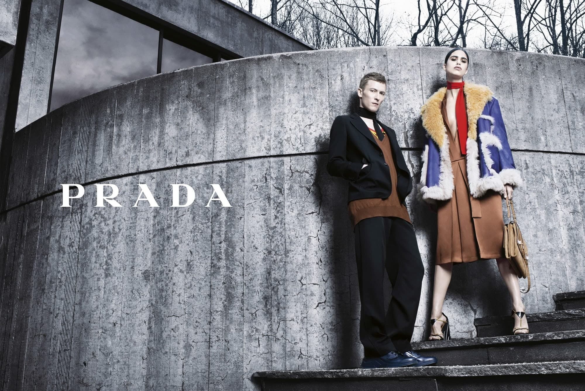 Prada campaign: two models on concrete steps beneath a curved wall